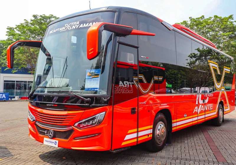 Bus pariwisata besar berwarna merah-oranye